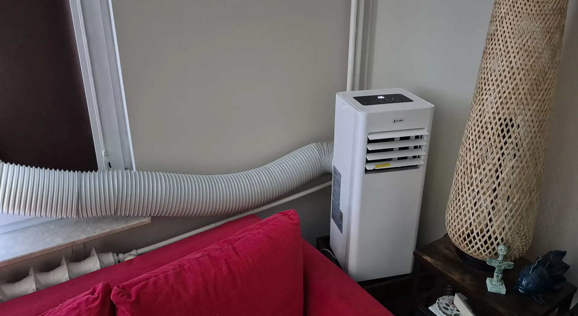 Klimatyzator przenośny BluMill 9000 BTU zamontowany przy oknie w pokoju